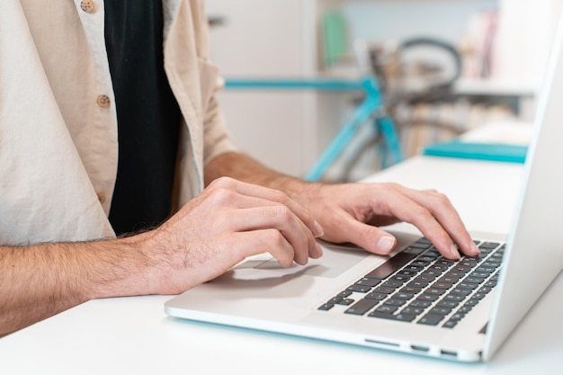 Onherkenbare man werknemer werkt aan laptop op bureau kantoor bijgesneden afbeelding man typen op computer