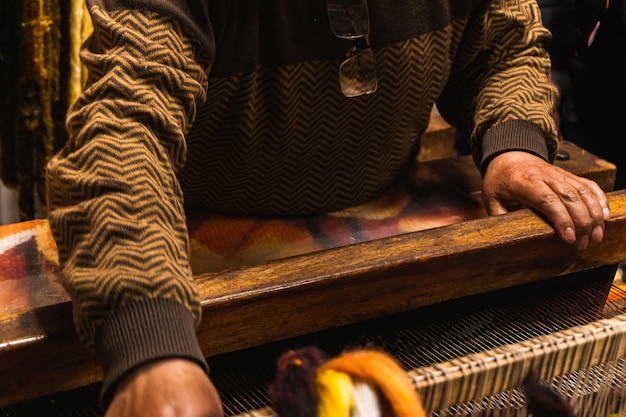 Onherkenbare oude mannen uit San Pedro de Cajas die op traditionele wijze weefgetouwen maken met een wodden machine textiel gemaakt van schapen alpaca en vicuna wol Tarma Junin Peru