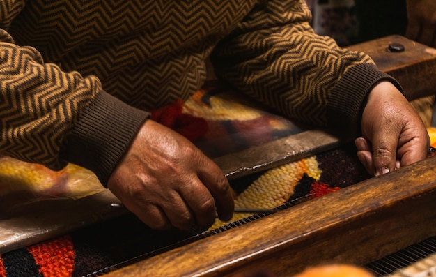 Onherkenbare oude mannen uit San Pedro de Cajas die op traditionele wijze weefgetouwen maken met een wodden machine textiel gemaakt van schapen alpaca en vicuna wol Tarma Junin Peru