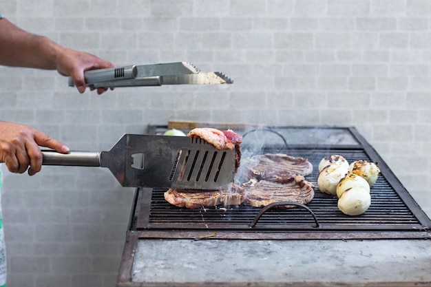 Onherkenbare persoon kookt een barbecue op een grill