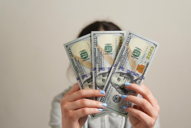 Onherkenbare persoon met drie ne 100 Amerikaanse bankbiljetten - zakelijk, financieel concept