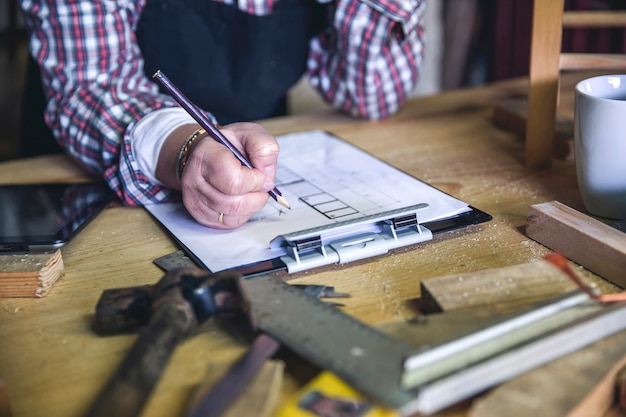 Onherkenbare senior vrouwelijke timmerman aan het werk in haar atelier