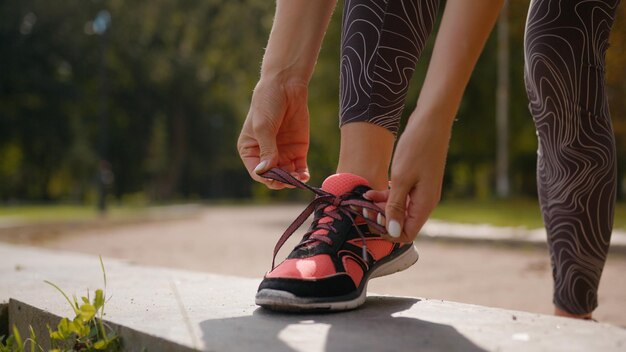 Onherkenbare sportieve vrouw die schoenveters bindt en loopt voorbereide sneakers vrouwelijke sportopleiding