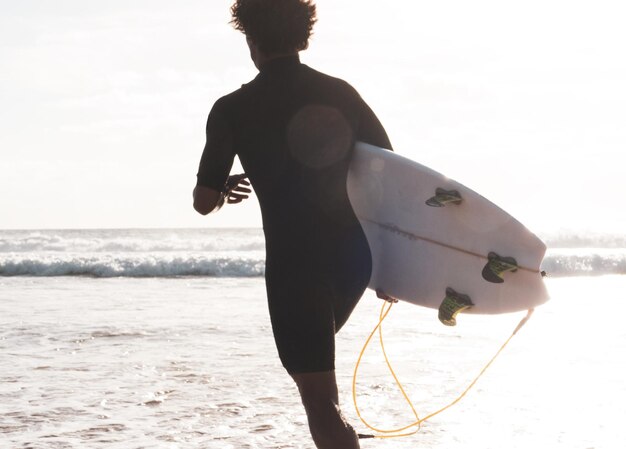 Onherkenbare surfer die naar de golven rent