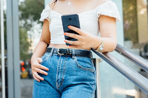 Onherkenbare vrouw die een bericht schrijft op haar smartphone