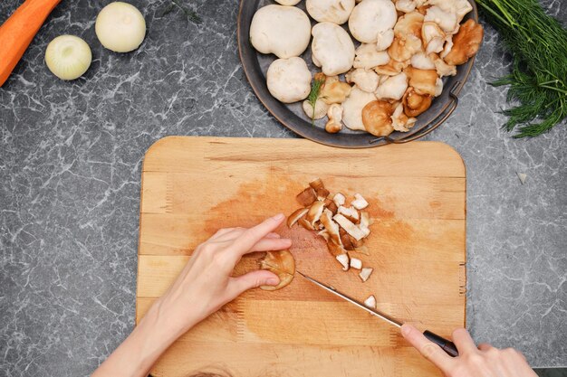 Onherkenbare vrouw die groenten snijdt terwijl ze gezond eten maakt