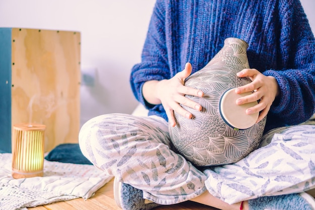 Onherkenbare vrouw die het udu-trommel Afrikaanse percussie-instrument speelt