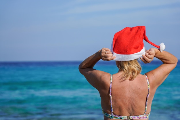 Onherkenbare vrouw die kerstmuts in kerstvakantie zet