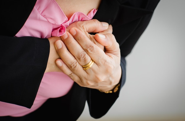 Onherkenbare vrouw die lijdt aan een plotselinge hartaanval en houd de borst vast. Concept van spoedeisende gezondheidszorg en getroffen door congestief falen of cardiopulmonale reanimatie, hartprobleem.