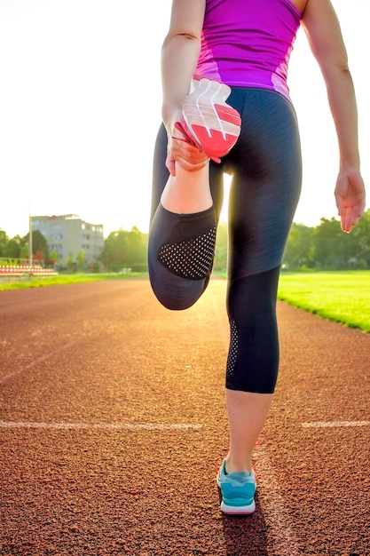 Onherkenbare vrouw die opwarmt voordat ze gaat joggen Buiten trainen