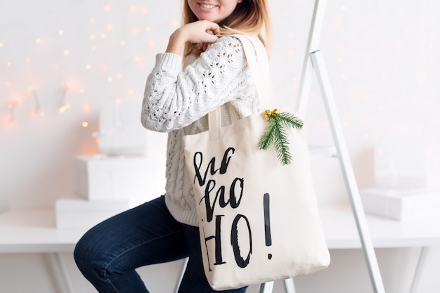 Onherkenbare vrouw met kerstcadeau in stoffen tas