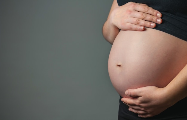 Onherkenbare zwangere vrouw die haar buik streelt