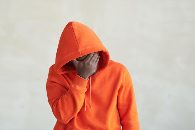 Onherkenbare zwarte man in oranje hoodie