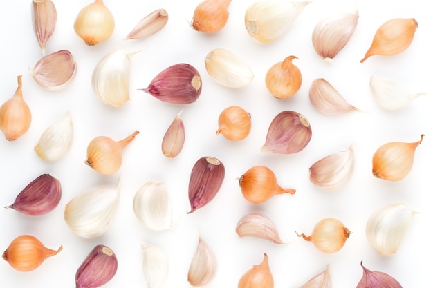 Onion and garlic isolated on white background, top view. Wallpaper abstract composition of vegetables.