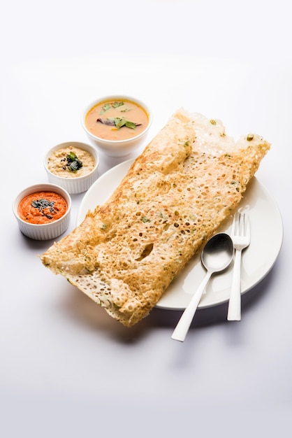 Foto la cipolla rava masala dosa è una colazione istantanea dell'india meridionale servita con chutney e sambar su uno sfondo lunatico. messa a fuoco selettiva