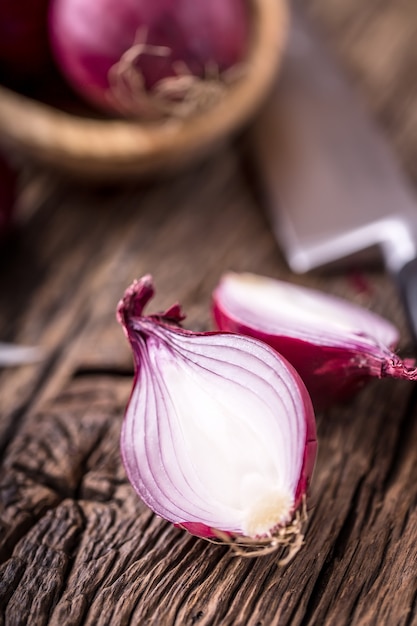 Onion. Red onions on very old oak wood board. Selective focus.