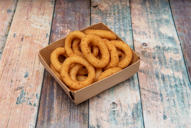 Onion rings battered in flour and egg and then fried in a take away container