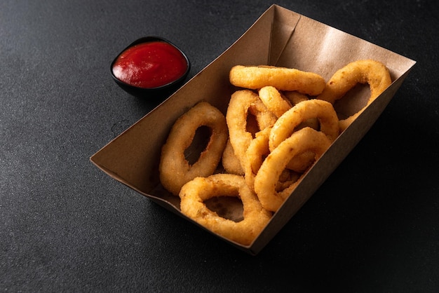 Onion rings in a paper box the concept of food delivery