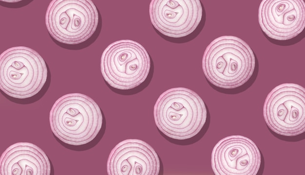 Photo onion slices on purple background, top view