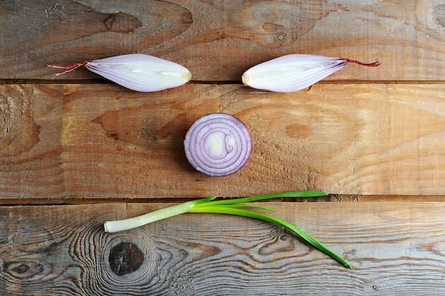 Foto cipolle di diverse varietà su fondo di legno rustico