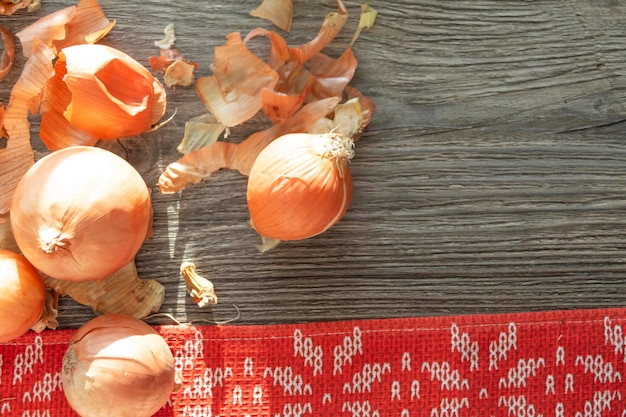 Onions napkins and onion husks are in the kitchen on a wooden gray table