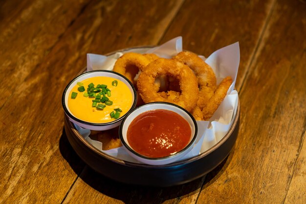 onions ring with ketchup and sauce on plate