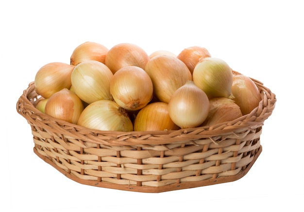 Onions in wicker basket on white background