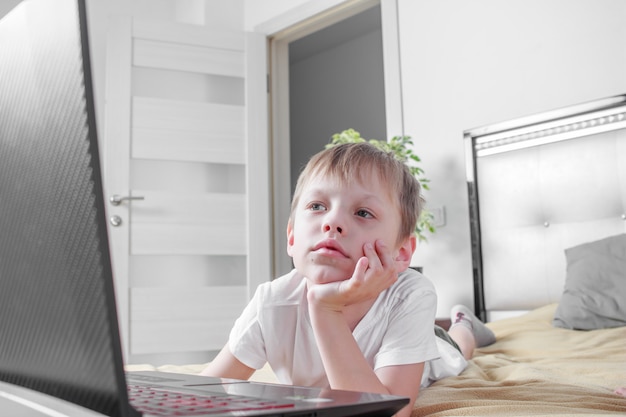 Online afstandsles thuis tijdens sociale quarantaine op afstand, zelfisolatie. Huiswerk op laptop tijdens pandemie.