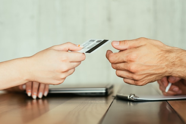 Online banking and financial operations on the internet. electronic money transfer. two people holding credit or debit bank card.