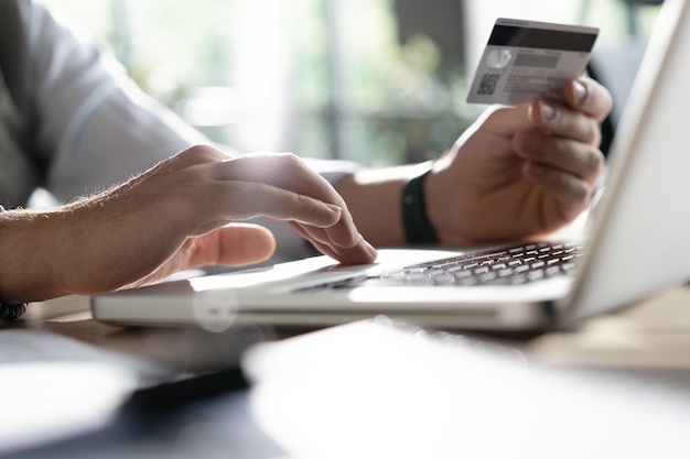Online betaling Man's handen houden een creditcard vast en gebruiken een smartphone om online te winkelen