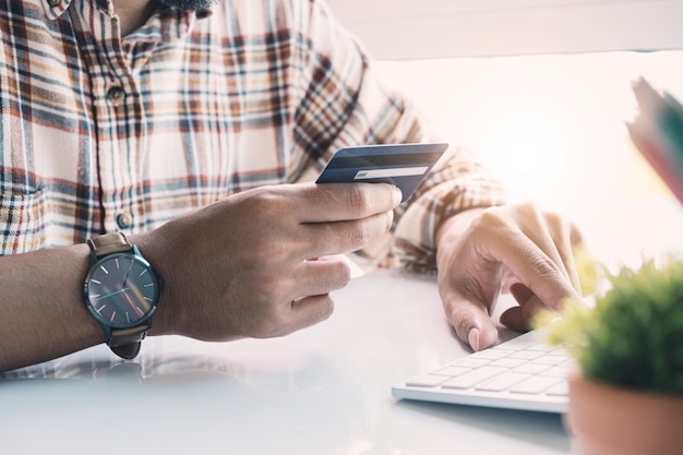 Online betaling, Man's handen met een creditcard en het gebruik van laptopcomputer voor online winkelen