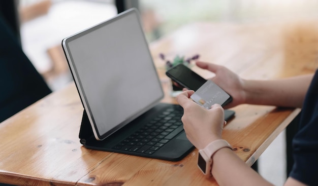 Online betaling, vrouwenhanden die een creditcard vasthouden en smartphone gebruiken en een product kiezen wat ze wil voor online winkelen.