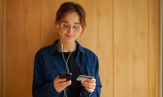 online betalingen Meisje heeft een smartphone en een creditcard Europese vrouw die online winkelt