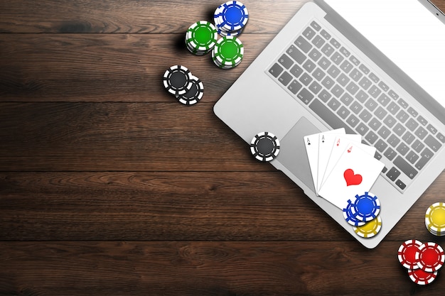 Online casino, laptop, chips cards on wood