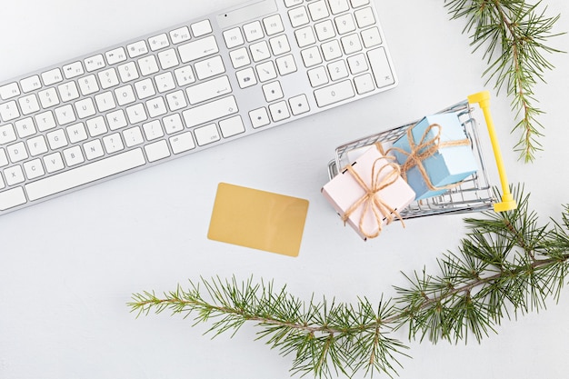 Online christmas shopping with gift boxes, keyboard and mockup of golden credit card