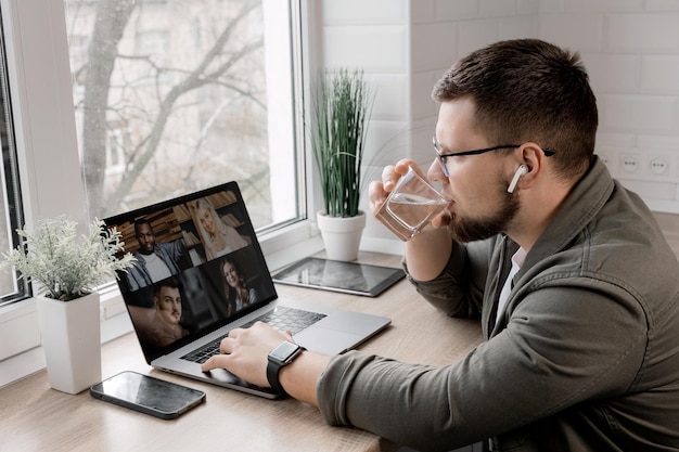 Online conference at a distance The guy works at home and drinks water Healthy lifestyle