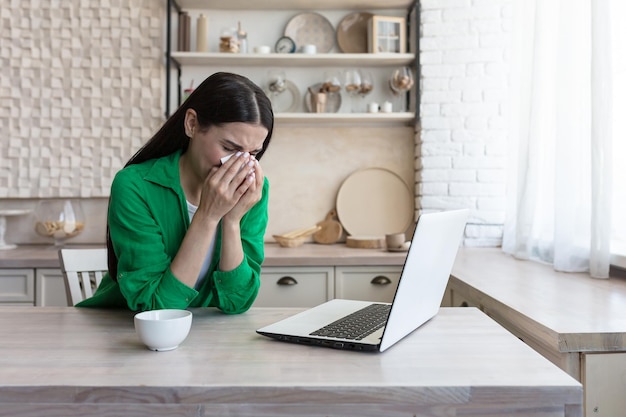 Online consultation with a family psychologist a young beautiful woman in the kitchen cries in