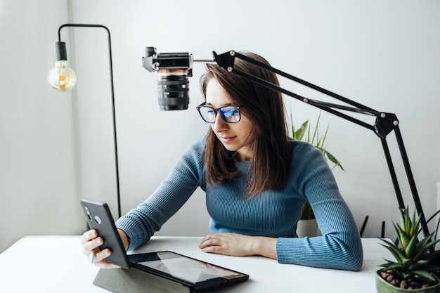 Online content creator vlogger. een jonge vrouwenblogger met een bril verwijdert de inhoud van de blog, trainingen. het concept van online leren tekenen op walercolor