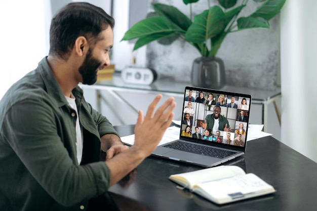 Photo online conversation online business meeting brainstorm of employees indian successful man ceo talking on video conference call with colleagues of different nationalities discussing the project