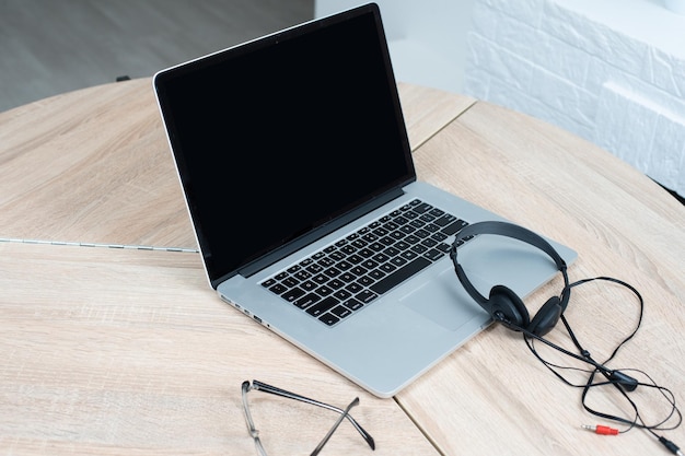 online conversation using laptop and headphones at office desk