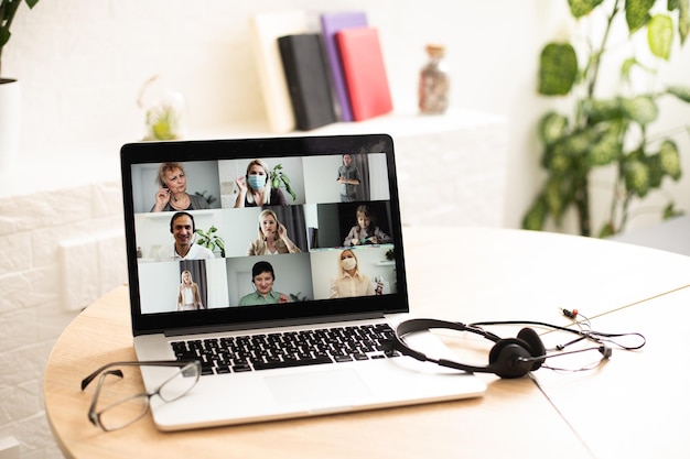 online conversation using laptop and headphones at office desk