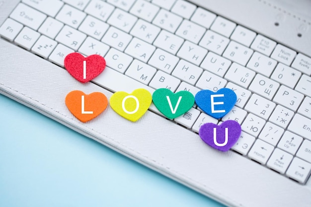 LGBTプライドカラーのシンボルハートとオンラインデートコンピュータのキーボード