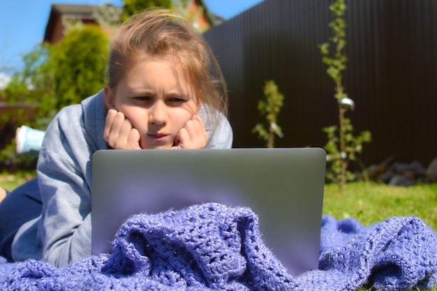 Online distance learning outdoor. Home schooling. The girl does not understand homework.