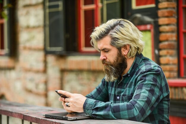 Online distant education hipster inspired to work agile business mature student working on computer go shopping on cyber monday bearded man in cafe with laptop and phone Ready to study