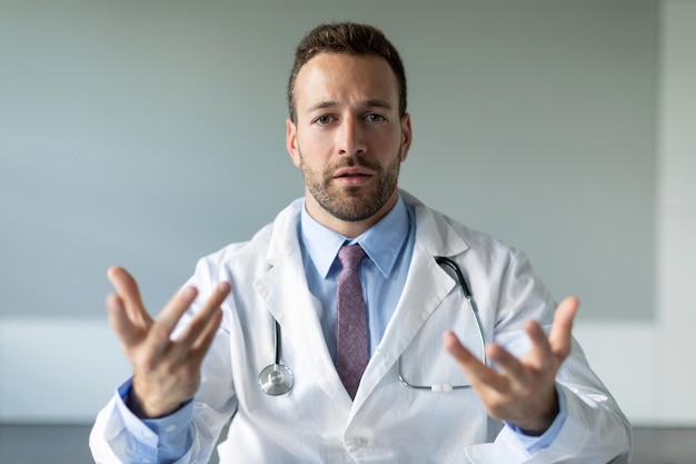 Online doctor confident man physician giving consultation online video calling with patient sitting