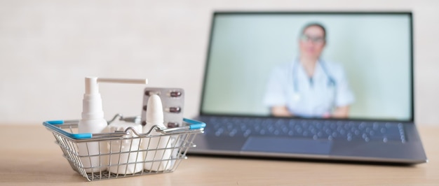 Online doctor Medical worker at a remote consultation A computer application for the purchase of medicines in a pharmacy with home delivery Pharmacist on laptop screen and basket full of drugs