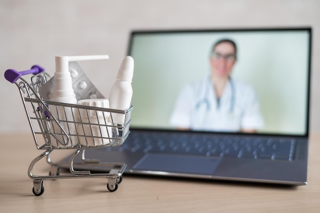 Online dokter Medisch medewerker op consultatie op afstand Een computerapplicatie voor de aankoop van medicijnen in een apotheek met thuisbezorging Apotheker op laptopscherm en karretje vol medicijnen