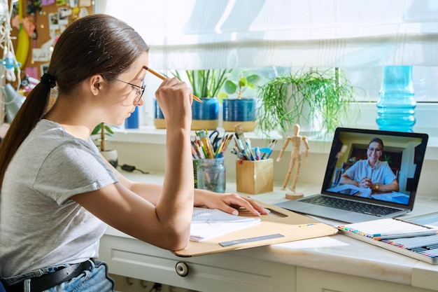 写真 先生とビデオ会議をしているオンライン描画レッスンの10代の少女