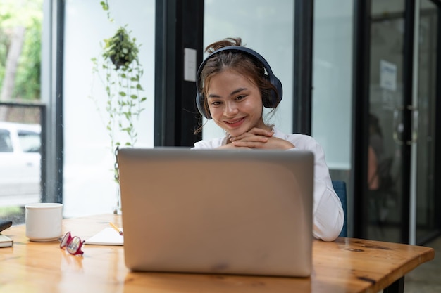 Online education elearning young woman studying remotely using a laptop listening to online webinar at home