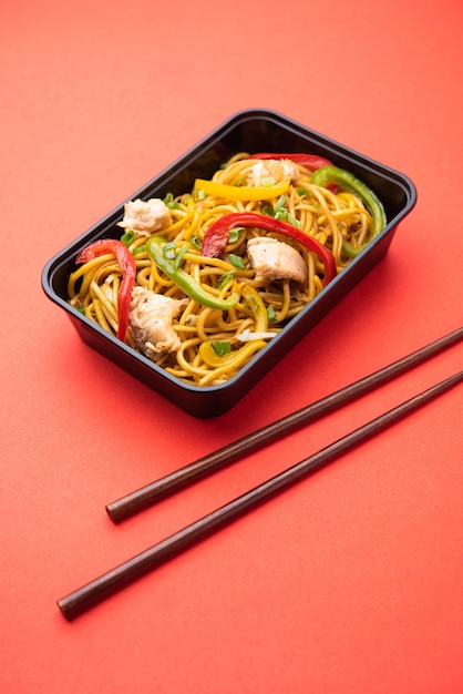 Online eten bestellen, bezorgen in india - schezwan noodles, kip hakka noodles verpakt in plastic doos